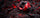 A red and black spinning fishing reel resting on dark textured rocks with glowing red embers in the background.